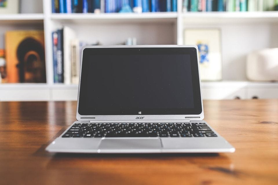 A laptop and notebook on a desk
